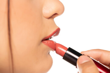 closeup of a young beautiful woman applies lipstick