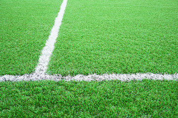 Obraz premium Artificial grass of football field with white stripe, Soccer line detail, Green astro turf for texture background, Perspective
