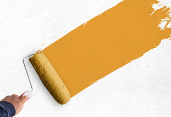 hand holds paint roller and painting a wall

