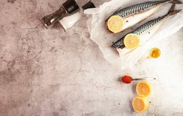 Fresh raw mackerel fish. On a gray background. Raw fish with lemon and dressings