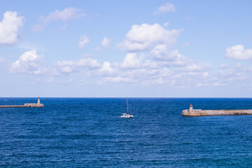 Obraz premium Landschaft mit Segelboot und Leuchttürmen in Valletta, Malta