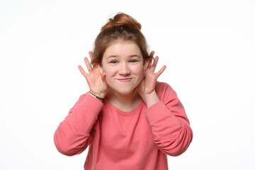 Close-up portrait of cheerful young girl making funny face. White background