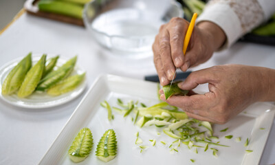 Chef carves patterns on cabbage and other vegetables and fruits for a beautiful table decoration