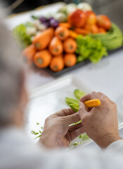 Chef carves patterns on cabbage and other vegetables and fruits for a beautiful table decoration