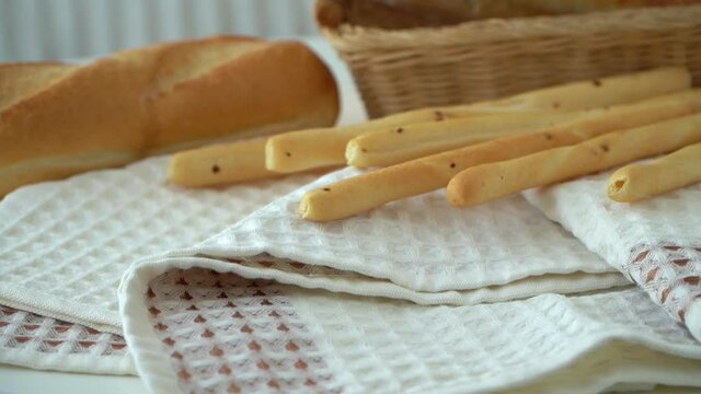 Waffle kitchen towels on background of basket with bread and bread sticks. Cotton dish towels. Tea towel. Textile industry