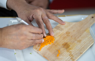 Chef carves patterns on cabbage and other vegetables and fruits for a beautiful table decoration