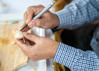 Chef carves patterns on cabbage and other vegetables and fruits for a beautiful table decoration