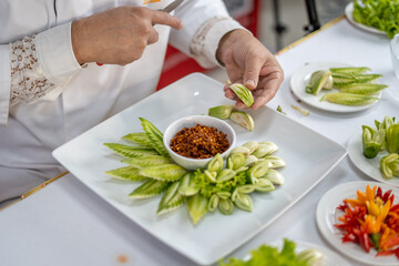 Chef carves patterns on cabbage and other vegetables and fruits for a beautiful table decoration