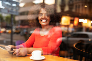 Businesswoman using tablet in cafe. Beautiful woman sitting in cafe, reading the news online.