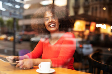 Businesswoman using tablet in cafe. Beautiful woman sitting in cafe, reading the news online.
