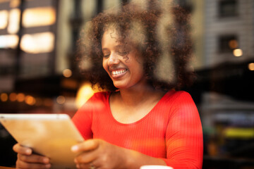 Businesswoman using tablet in cafe. Beautiful woman sitting in cafe, reading the news online.