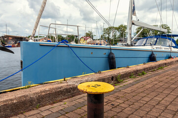 beautiful sailboat moored to the port of Darłowo on the Baltic Sea. A mooring post in the...