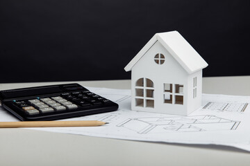 White house and calculator on architectural project. House building costs concept