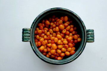 Sea buckthorn berries in a green round cup