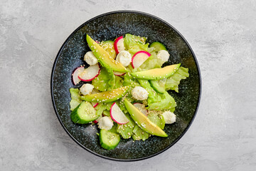 Overhead view of salad with lettuce, avocado, radish and mozzarella