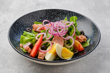 Salad with lettuce, salmon, tomato, boiled egg and onion