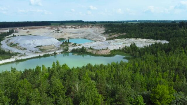 Quarry lake in abandoned kaolin pit among forest, aerial view