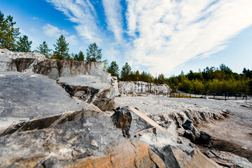 The rock has carved an untreated surface of white and gray marble in a natural environment. The quarry texture of blue marble.