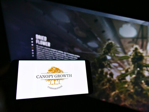 STUTTGART, GERMANY - Mar 07, 2021: Person Holding Smartphone With Logo Of Company Canopy Growth Corporation On Screen With Website.