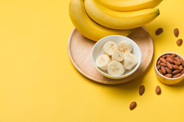 Bananas and banana slices on a plate of wood.