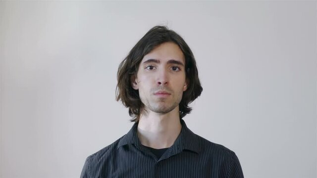 Young adult man showing timeout gesture, wearing dark shirt, 4k footage