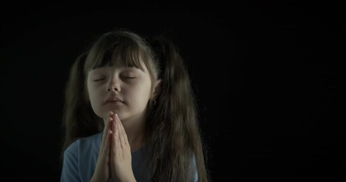 Child with faith. A little girl with faith pray and speak with God in the night.