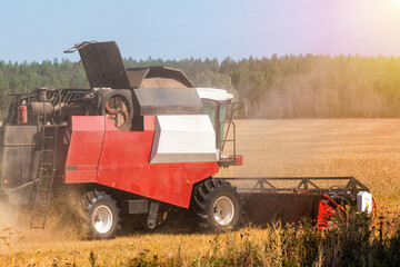 Modern combine harvester working in the field on a clear sunny day