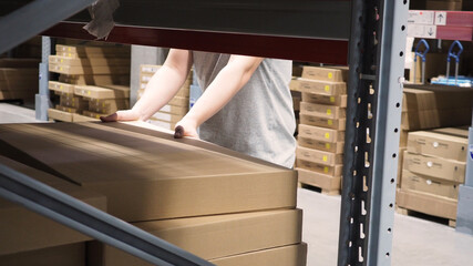 Warehouse large storage or logistic or cargo for distribution. and man's hand is picking up a box.