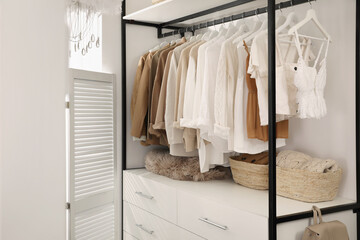 Rack with stylish women's clothes in dressing room