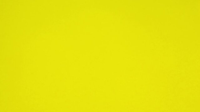 Looped stop motion animation with pink and yellow background. A paper ball spreads making a blank sheet for text