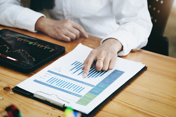 New normal, self-employed women pointing document stock and using a tablet to trade stocks for profit, buying and selling.