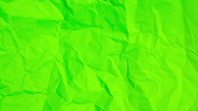 Looped Stop motion of Crumpled neon green paper texture background.