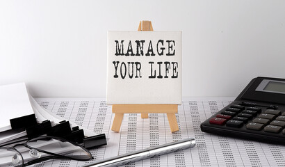 text MANAGE YOUR LIFE on easel with office tools and paper.Top view. Business concept