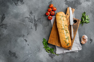 Baguette with parsley herbs butter, on gray stone table background, top view flat lay, with copy...