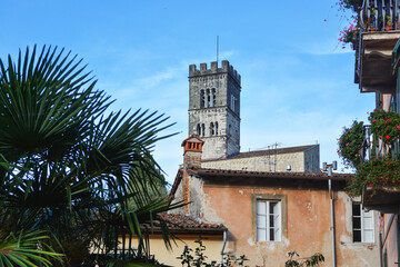 Fototapeta na wymiar Blick aus der Altstadt von Barga in der Toskana auf den Dom. Der Turm des Domes ragt in den blauen Himmel