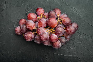 Finest natural home bunch of grapes, dark red fruits, on black stone background, top view flat lay