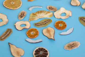 Obraz na płótnie Canvas Dried fruits Colored blue background Useful vitamins Kiwi Coconut Pear Orange Banana Mandarin Lime