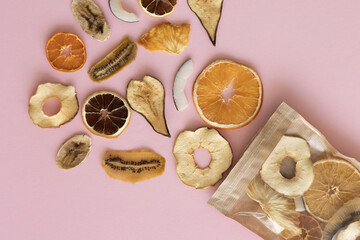 Fototapeta na wymiar Dried fruits near a paper eco-friendly bag lie on the background