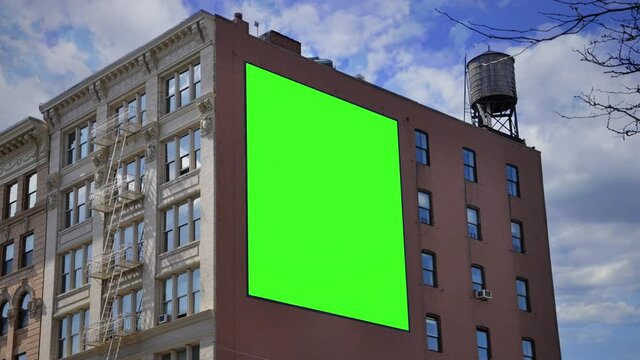 Billboard Building Wall Green Screen Zoom In Panel Cloudy Sky. A large billboard with a green screen on a building wall under a cloudy sky. Zoom in