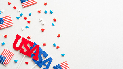 American flags, confetti stars and US decorations on white background. Flat lay, top view. Happy Independence Day, American Labor day, US Memorial Day, Columbus day banner design