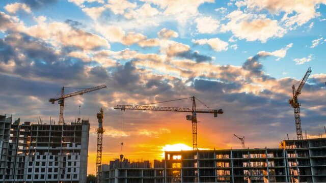 A Beautiful Time Lapse Footage of a Big Construction Site with Several Working Cranes, with Cloudy Sky at Sunset. 4K.
