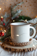 Cocoa mug on wooden stand and knitted sweater