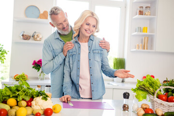 Photo of smiling cheerful good mood married couple wife and husband prepare delicious meal breakfast at home indoors
