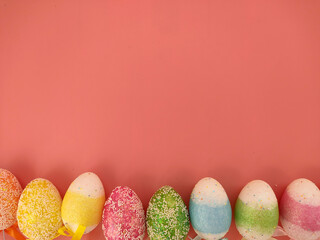 Top view of Easter eggs on pink background