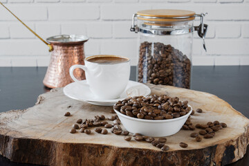 A cup of Turkish coffee and beans on a piece of wood. Selective focus 