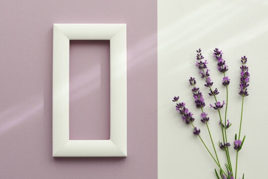 Mockup with white frame on lilac background next to bunch of  lavender on white background.