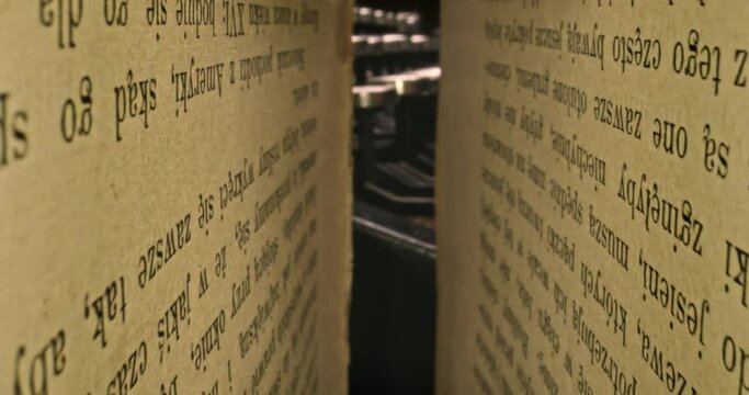 Old typewriter hidden behind old book. Vintage journalist desk.