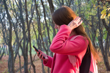 Faceless woman browsing smartphone in park