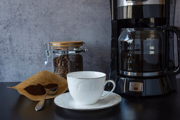 coffee machine, a cup, a jar full of coffee beans and a spoon of turkish coffee