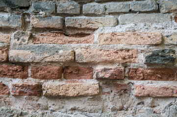 Grey white black red orange old vintage brick wall background. Rustic cemented brick house wall texture with grunge surface. Shabby Building Facade With Damaged Plaster